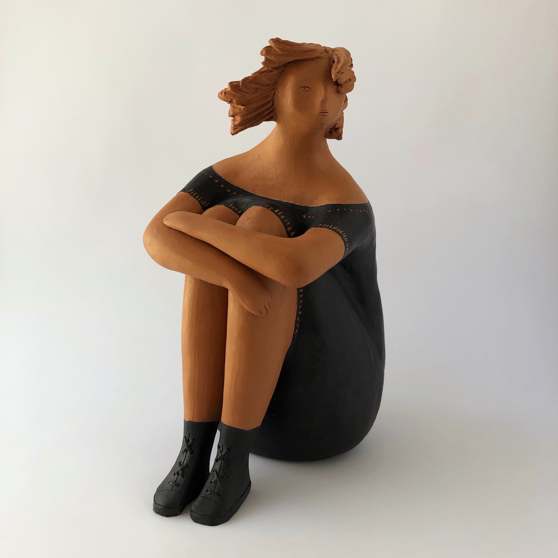 Donna con stivaletti in nero rappresenta una figura femminile seduta