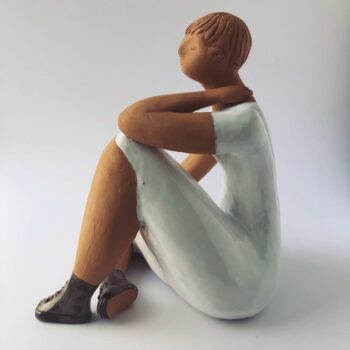 Woman Sitting in the Wind Dressed in White